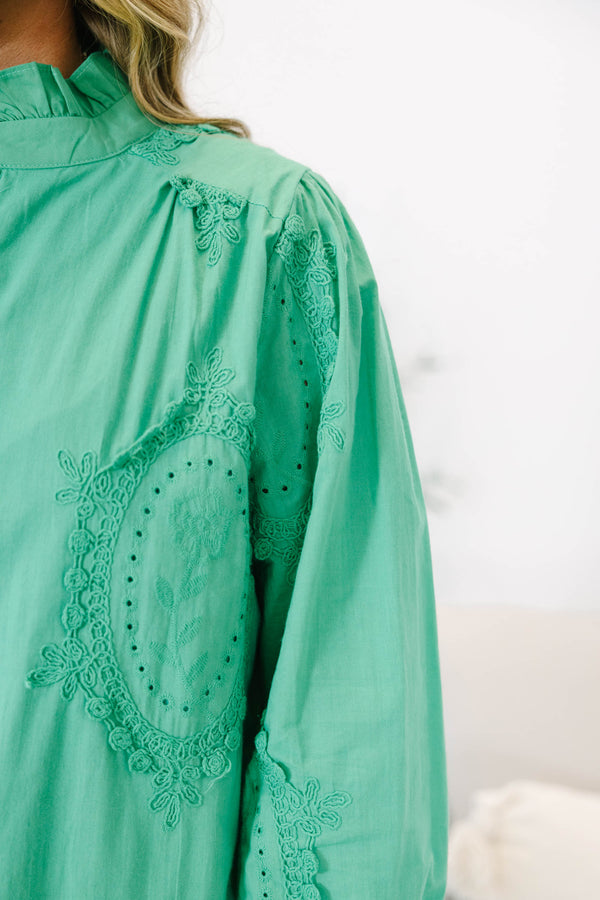 Plus size kelly green button-down top with tonal embroidery, ruffle collar, and smocked cuffs.