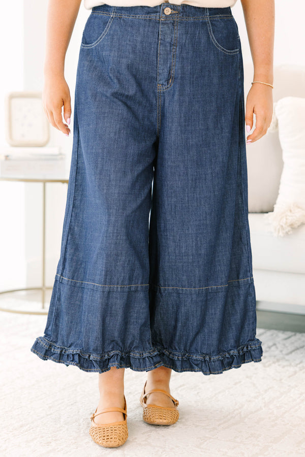 Plus size dark denim wide leg pants with a flowy fit and feminine ruffle hem detail.