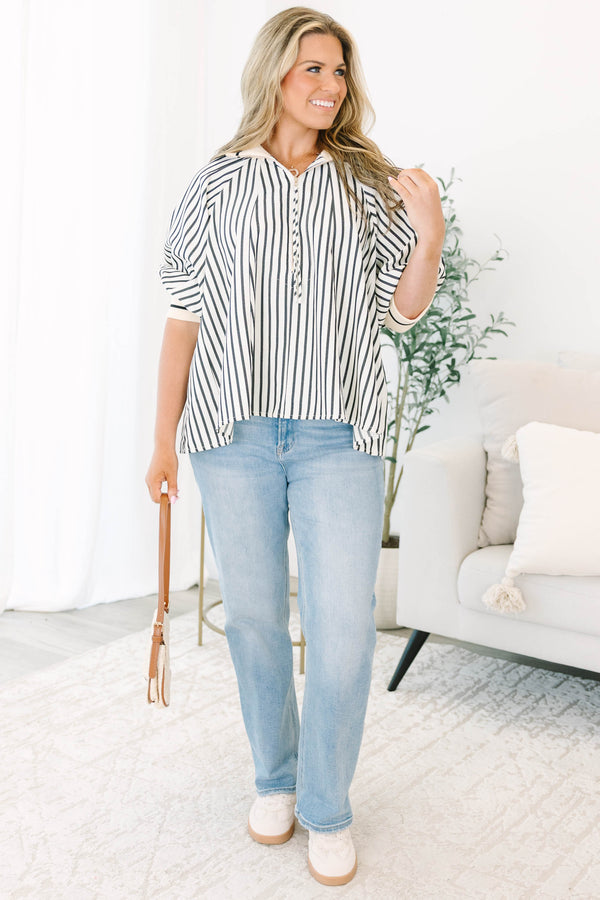 Plus size black and white striped top with a flowy fit, quarter-zip neckline, and ribbed cuffs.