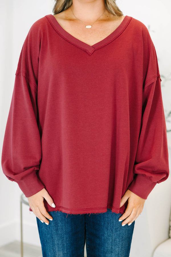 Plus Size burgundy V-neck pullover with long cuffed sleeves and a raw hemline.