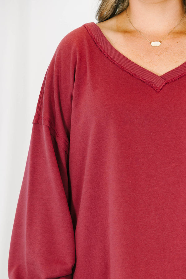 Plus Size burgundy V-neck pullover with long cuffed sleeves and a raw hemline.