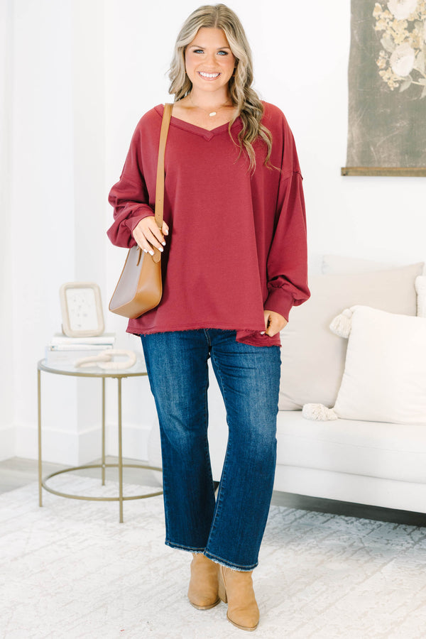 Plus Size burgundy V-neck pullover with long cuffed sleeves and a raw hemline.