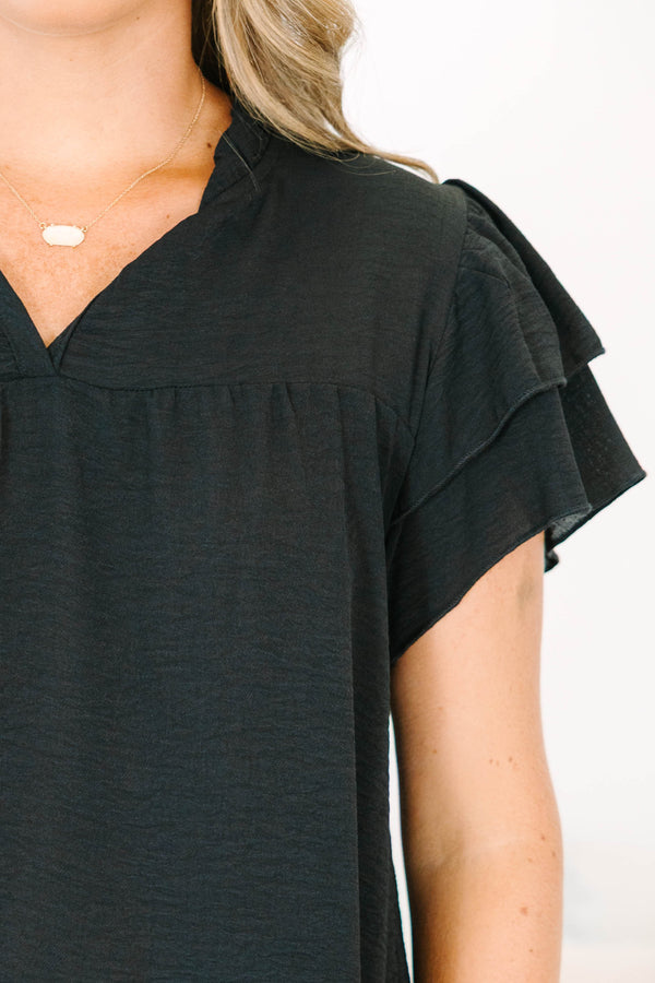 Plus Size black short sleeve top with tiered ruffle sleeves, a v-neckline, and a relaxed fit.