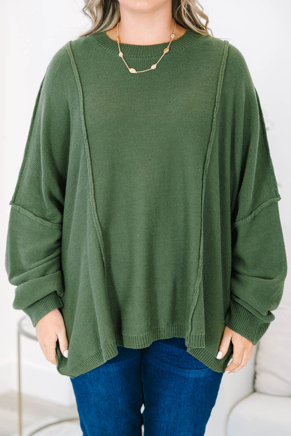 Plus size olive green oversized knit sweater with a flowy fit and exposed seam details.