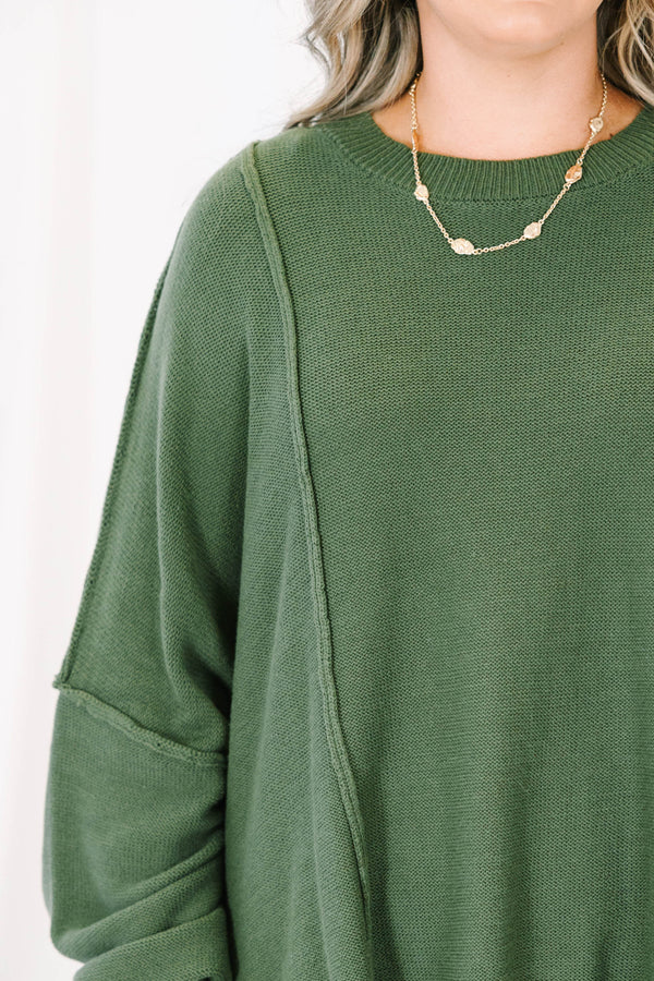 Plus size olive green oversized knit sweater with a flowy fit and exposed seam details.