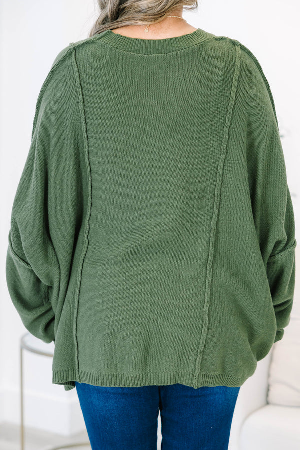 Plus size olive green oversized knit sweater with a flowy fit and exposed seam details.
