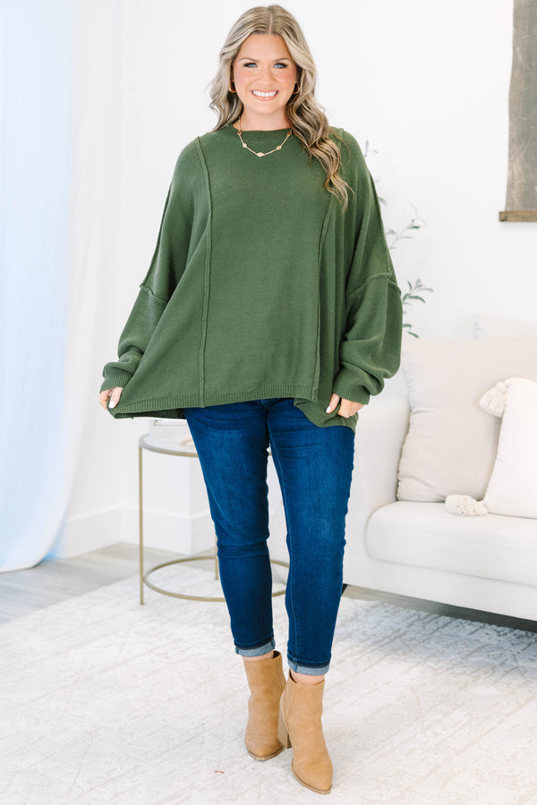 Plus size olive green oversized knit sweater with a flowy fit and exposed seam details.