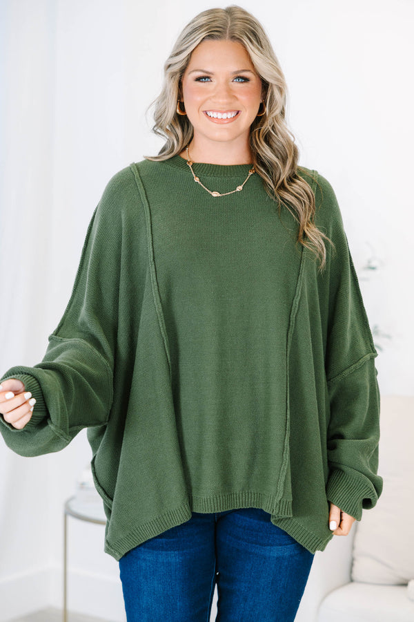 Plus size olive green oversized knit sweater with a flowy fit and exposed seam details.