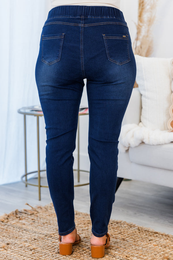Plus Size dark wash jeggings with a stretchy waistband, subtle distressing, and a skinny fit.