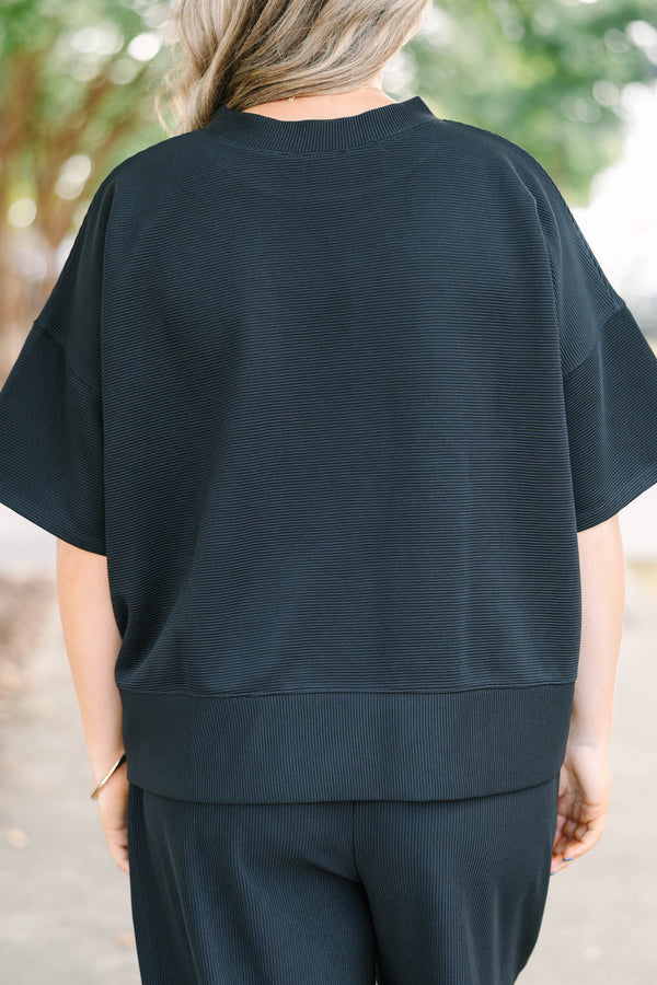 Plus size black ribbed knit lounge set with a boxy short sleeve top and matching pants.