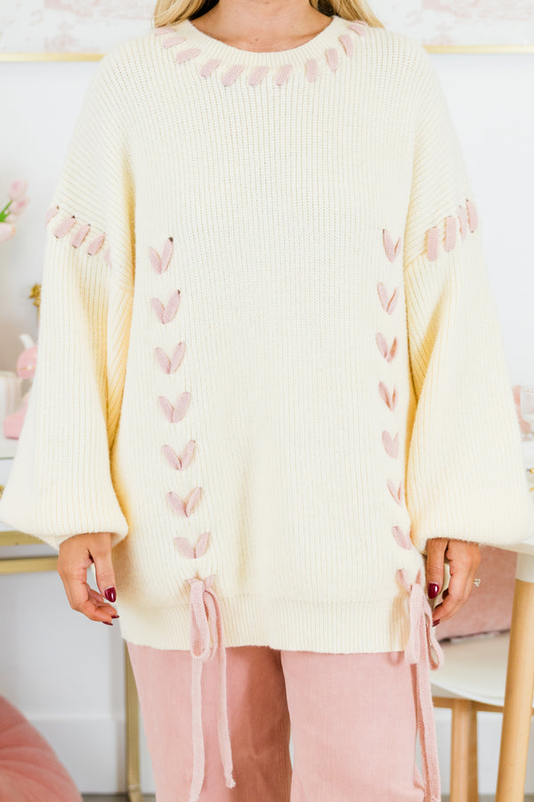 Chic Soul plus size clothing, ivory long sleeve sweater with pink robbin tied through the sweater around the neck, sleeves, and front