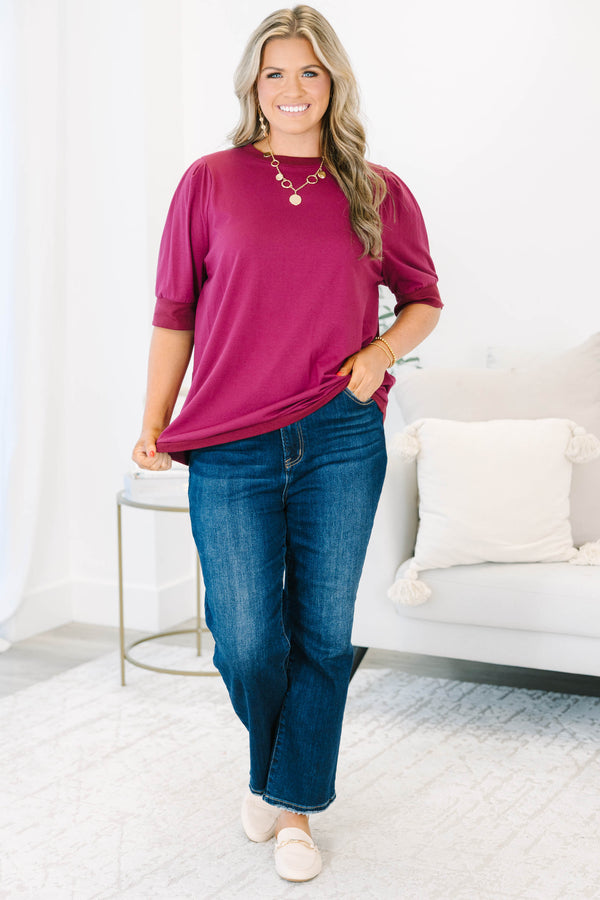 Plus Size burgundy short sleeve top with puffed shoulders and a round neckline.