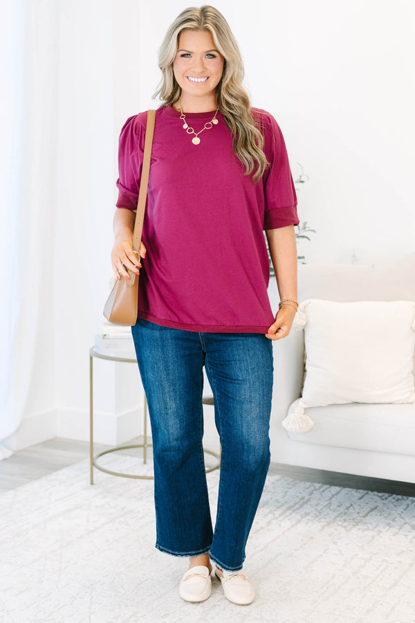 Plus Size burgundy short sleeve top with puffed shoulders and a round neckline.
