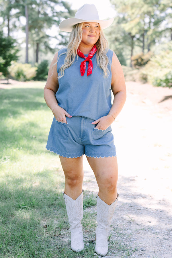 Plus Size denim shorts with white scalloped trim on the pockets and hem, paired with white boots.