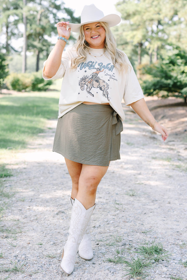 Plus Size olive green wrap-style skort with a side tie, paired with white embroidered cowboy boots.