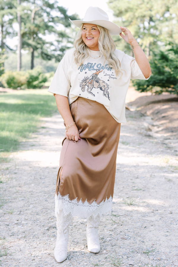 Plus Size sand vintage wash tee with a Wild West cowgirl graphic and a brown satin midi skirt.