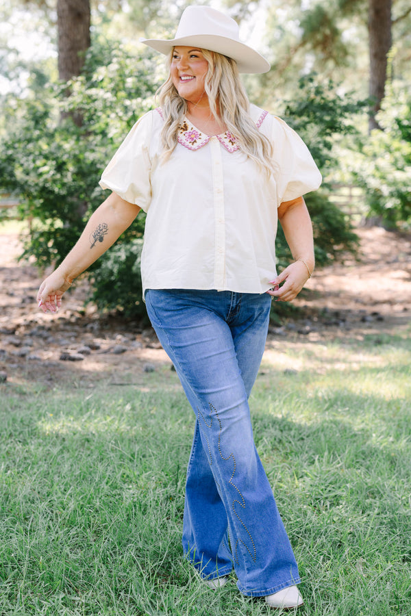 Plus Size medium wash flare jeans with studded embroidery along the outer side seams.