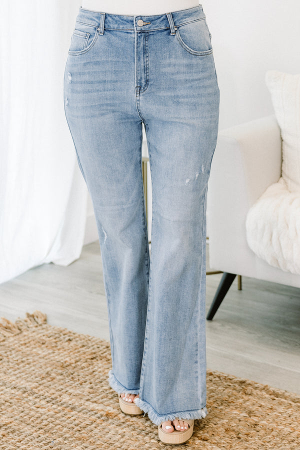 Chic Soul plus size clothing, high-waisted light wash slim-fitting bootcut blue jeans with subtle fraying along the hem and subtle distress on the legs