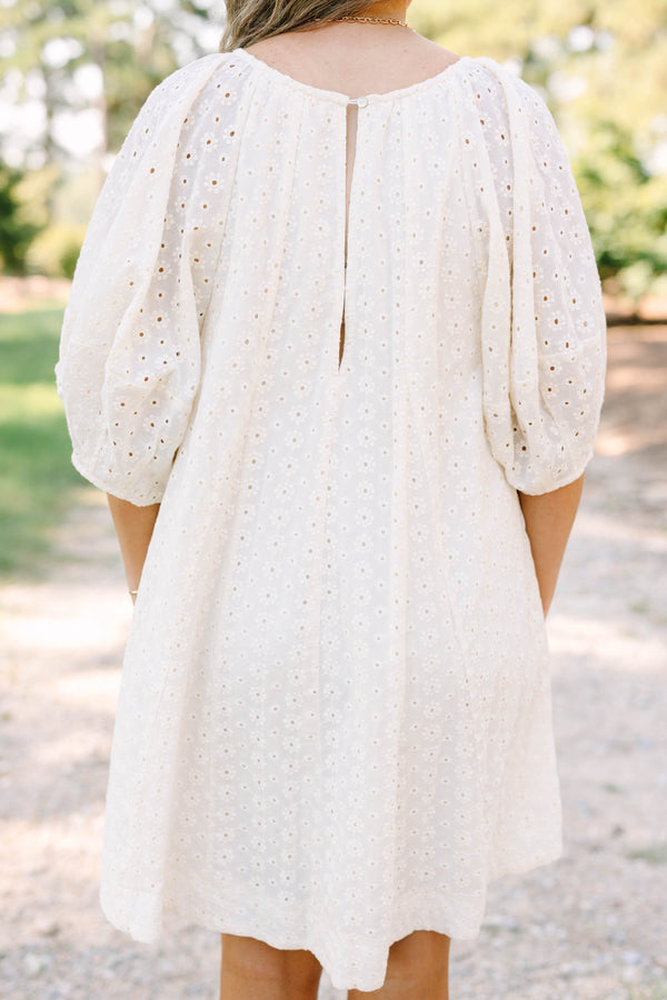 Plus Size ivory cotton eyelet dress with a scoop neckline, tie detail, and short puff sleeves.