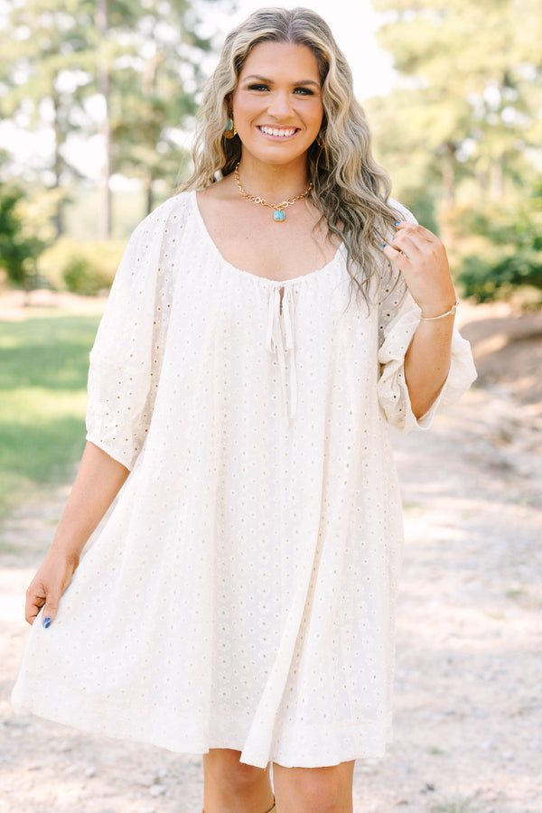 Plus Size ivory cotton eyelet dress with a scoop neckline, tie detail, and short puff sleeves.