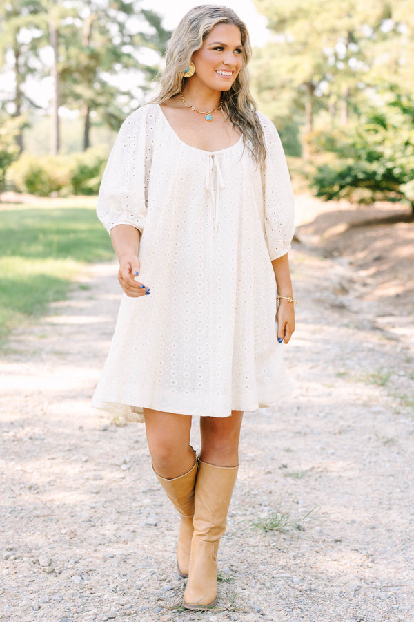 Plus Size ivory cotton eyelet dress with a scoop neckline, tie detail, and short puff sleeves.
