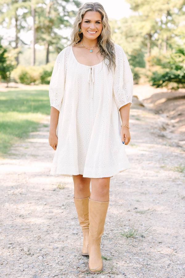 Plus Size ivory cotton eyelet dress with a scoop neckline, tie detail, and short puff sleeves.