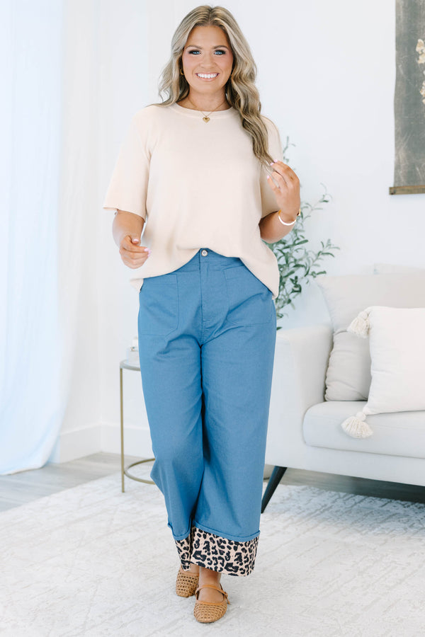 Plus size denim cropped pants with a wide leg fit and bold leopard print cuffed ankles.
