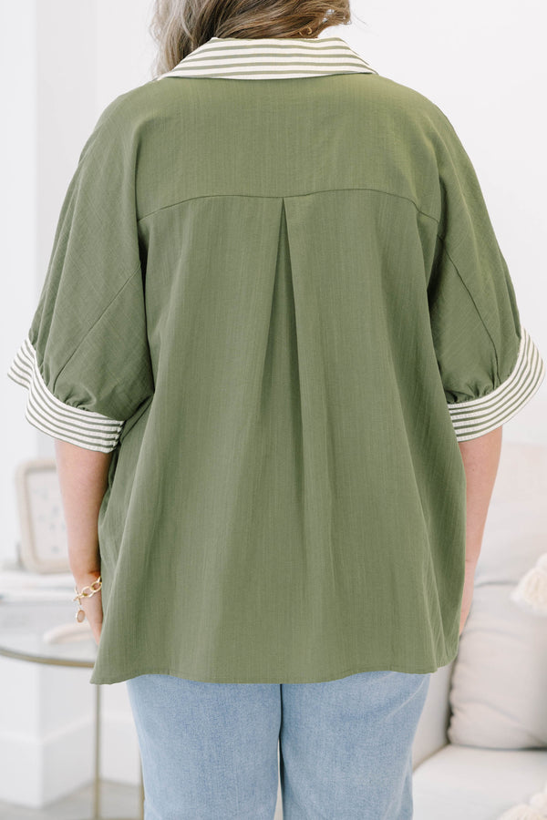Plus size olive green flowy top with a striped V-neckline and matching striped sleeve cuffs.
