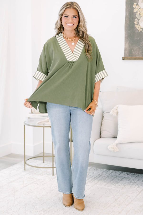 Plus size olive green flowy top with a striped V-neckline and matching striped sleeve cuffs.