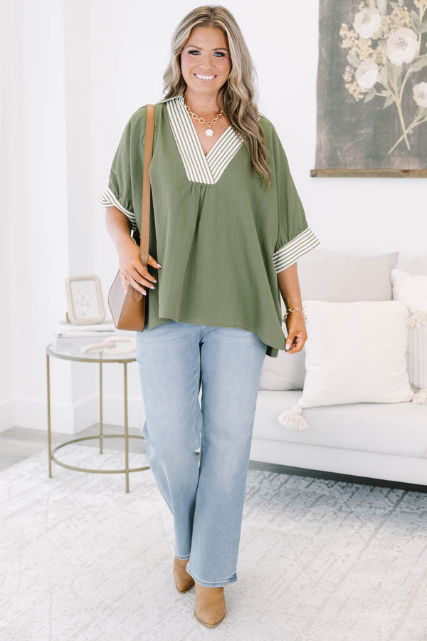 Plus size olive green flowy top with a striped V-neckline and matching striped sleeve cuffs.
