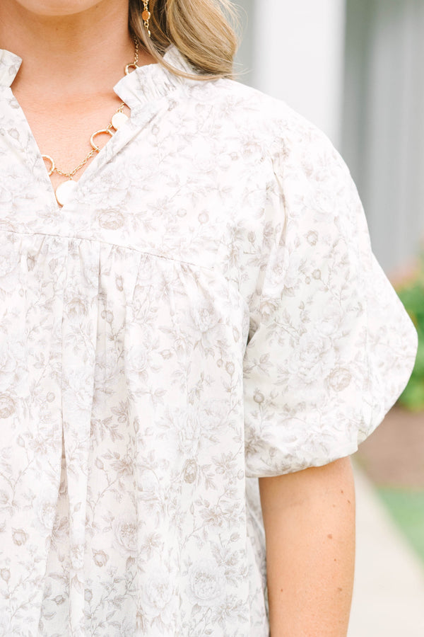 Plus Size cream floral blouse with a ruffled v-neckline and short elastic bubble sleeves.