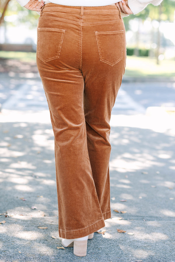 Plus size brown corduroy pants with a high-waisted, wide-leg silhouette and stretchy cotton fabric.