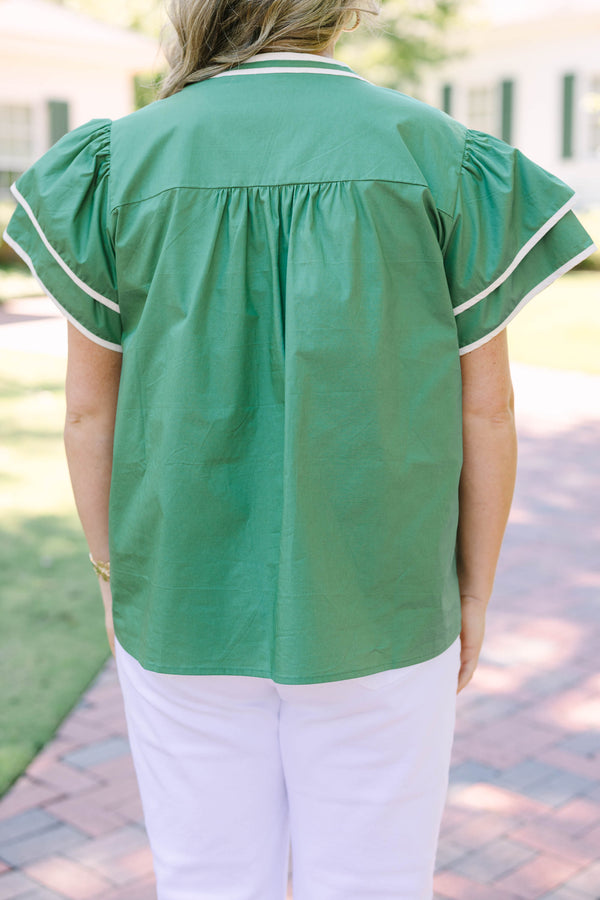 Plus size sage green top with white floral appliqué, ruffle sleeves, and a flowy silhouette.