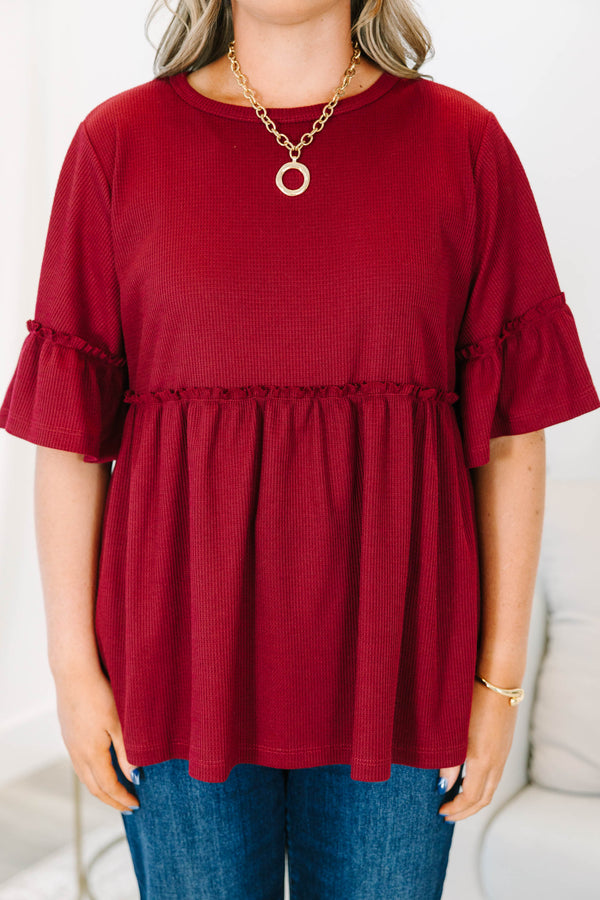 Plus Size burgundy waffle knit tunic with a round neck, ruffle sleeves, and a tiered babydoll fit.