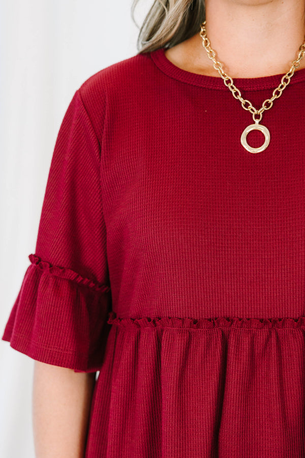 Plus Size burgundy waffle knit tunic with a round neck, ruffle sleeves, and a tiered babydoll fit.