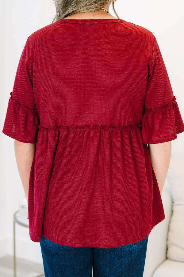 Plus Size burgundy waffle knit tunic with a round neck, ruffle sleeves, and a tiered babydoll fit.