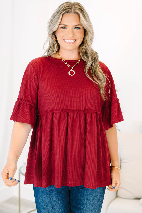 Plus Size burgundy waffle knit tunic with a round neck, ruffle sleeves, and a tiered babydoll fit.