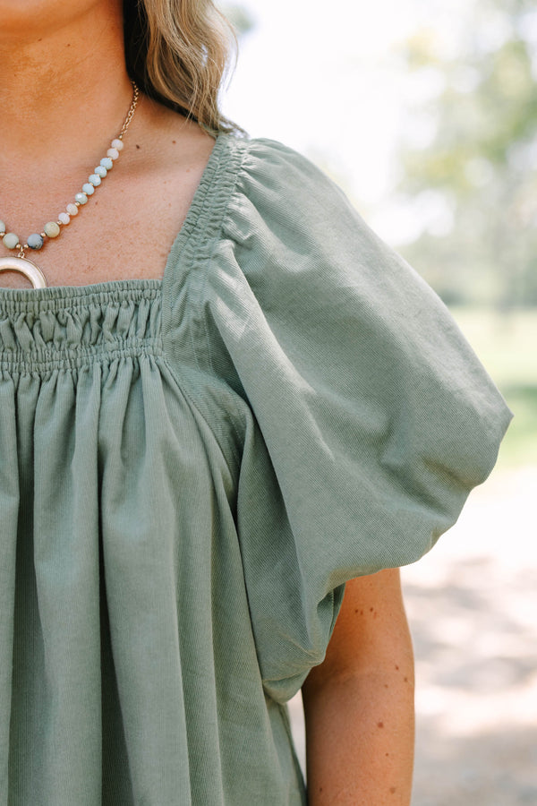 Plus size olive corduroy blouse with puff sleeves and a flowy fit.