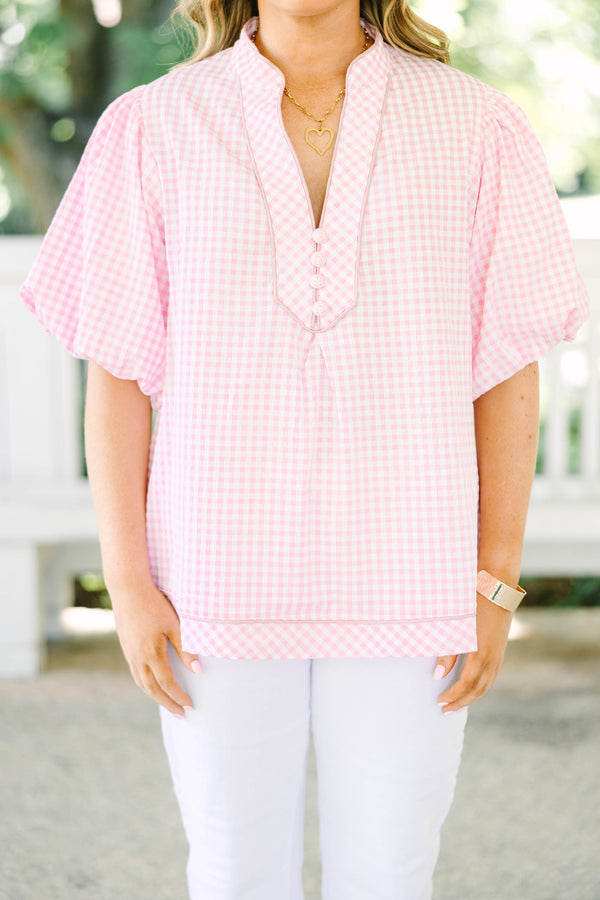 Plus size pink gingham top with puff sleeves and a v-neckline.