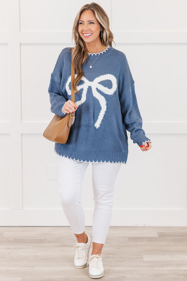 Chic Soul plus size clothing, blue long sleeve knit sweater with white bow knit design on the front with round neckline and cuff sleeves with white knit scalloped design along bottom, sleeves, and neckline