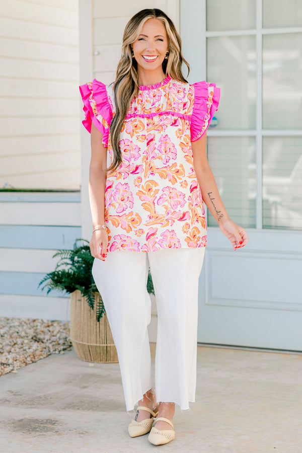Chic Soul plus size clothing, pink and orange top with a paisley pattern as we as flutter sleeves that have pink ruffle detail on the ends of the sleeves 
