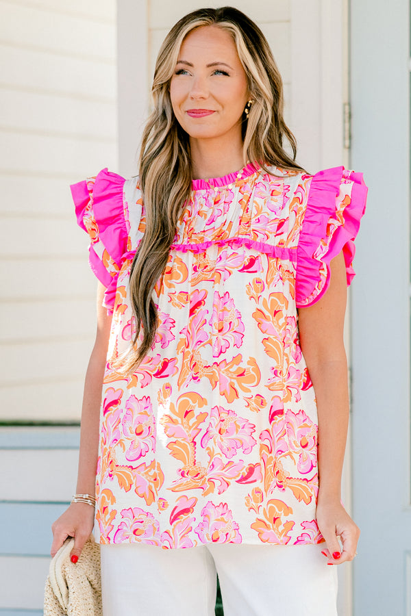 Chic Soul plus size clothing, pink and orange top with a paisley pattern as we as flutter sleeves that have pink ruffle detail on the ends of the sleeves 
