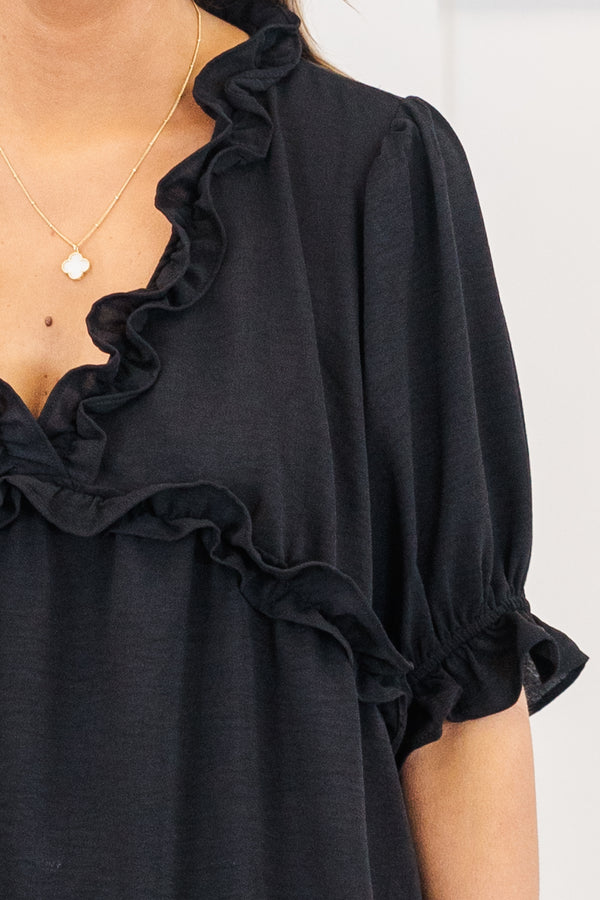 Plus Size black top with a ruffled v-neckline and elastic ruffle sleeves.