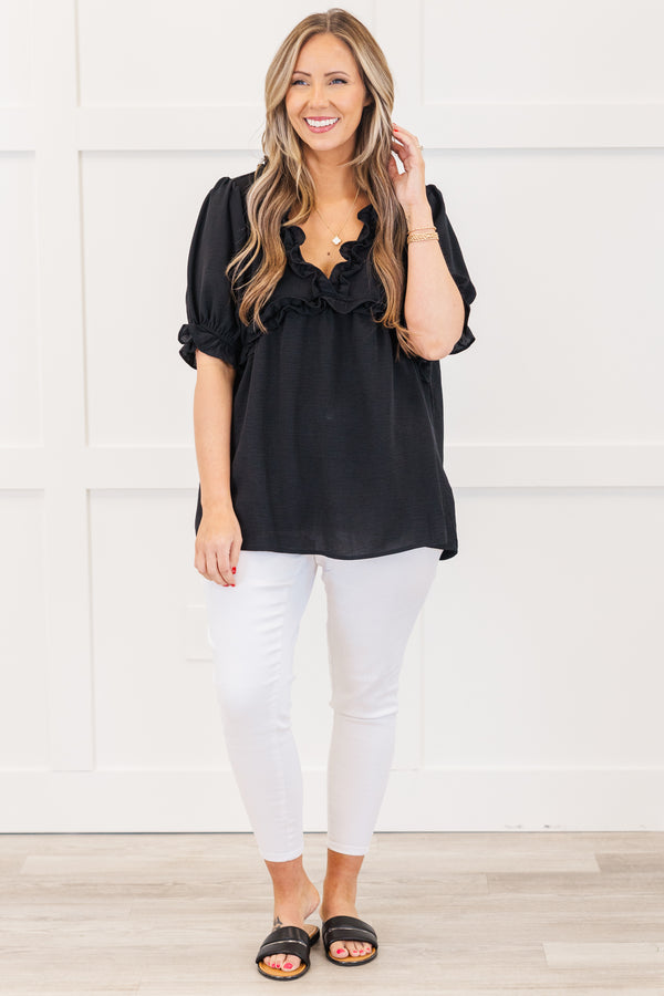 Plus Size black top with a ruffled v-neckline and elastic ruffle sleeves.