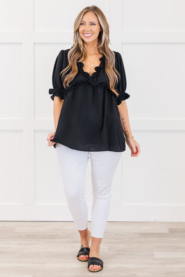 Plus Size black top with a ruffled v-neckline and elastic ruffle sleeves.