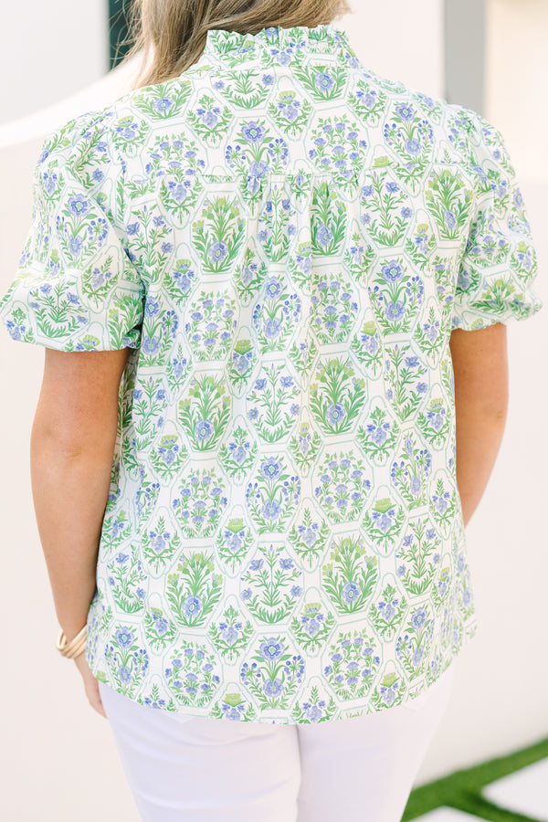Chic Soul plus size clothing, green top with bubbles that has a multi colored floral block pattern and two tassels hanging from the ruffle collar 
