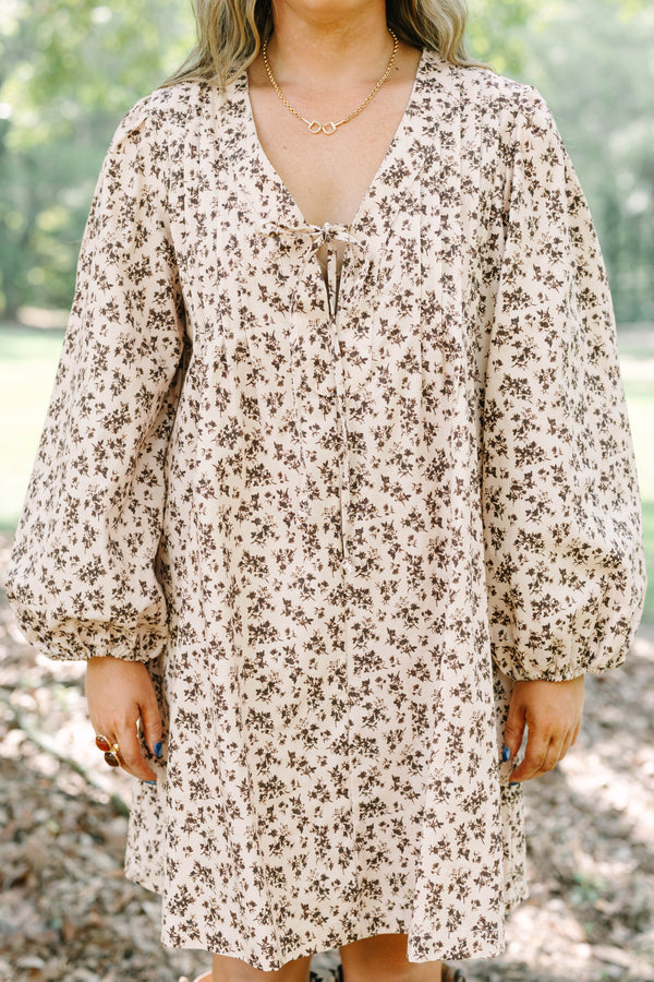 Plus size brown floral mini dress with a flowy fit, V-neck tie, and long puff sleeves.