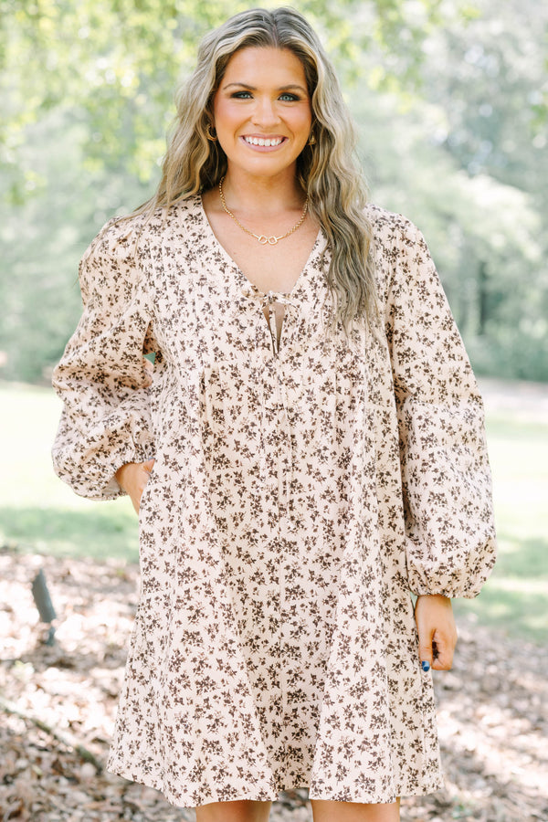 Plus size brown floral mini dress with a flowy fit, V-neck tie, and long puff sleeves.