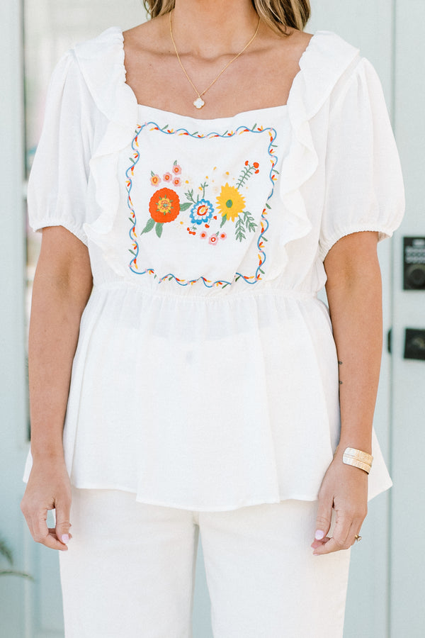 Plus Size white babydoll top with ruffled square neckline and colorful floral embroidery.