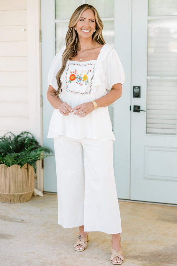 Plus Size white babydoll top with ruffled square neckline and colorful floral embroidery.